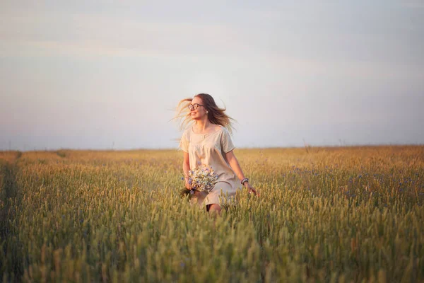 Çiçekli kız tahıl tarlasında yürüyor