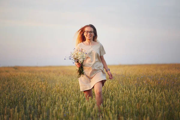 Çiçekli kız tahıl tarlasında yürüyor