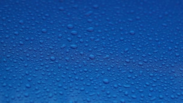 Gotas Lluvia Sobre Una Superficie Lisa Azul — Vídeo de stock