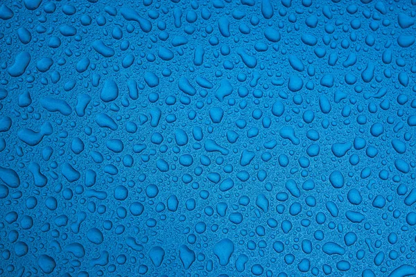 Rain drops on a blue smooth surface