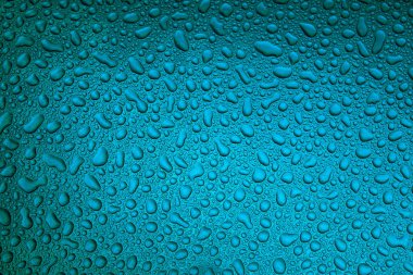 Mavi pürüzsüz bir yüzey üzerinde yağmur damlaları