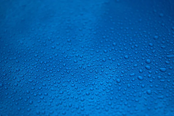 Rain drops on a blue smooth surface