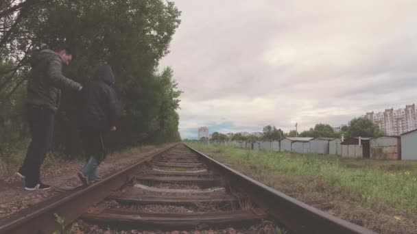 A criança com o pai anda nas trilhas ferroviárias . — Vídeo de Stock