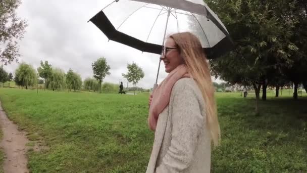 Mädchen unter einem Regenschirm bei schlechtem Wetter. — Stockvideo