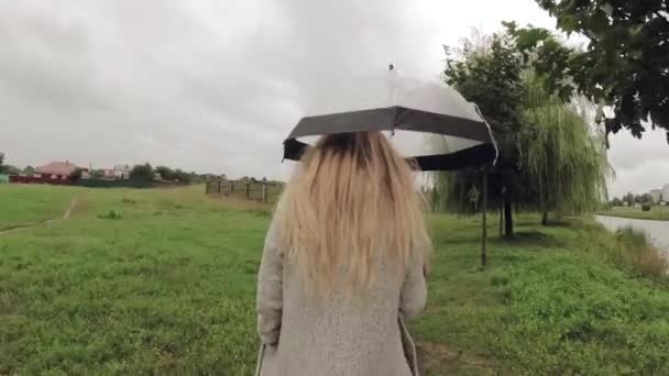 Dívka pod slunečníkem za špatného počasí. — Stock video