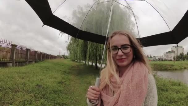 Menina sob um guarda-chuva em mau tempo . — Vídeo de Stock