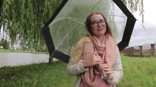 Mädchen unter einem Regenschirm bei schlechtem Wetter. — Stockvideo
