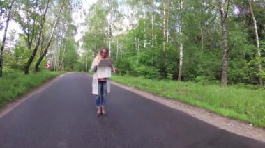 Kız yol boyunca yürüyor..