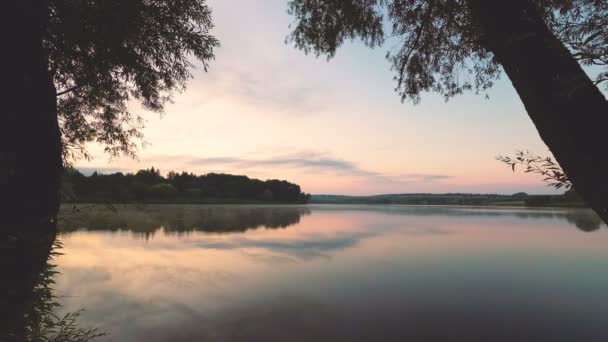 nuages se déplacent sur un lac brumeux le matin .