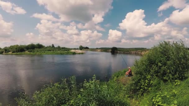 O pescador está pescando no rio com uma vara de pesca . — Vídeo de Stock