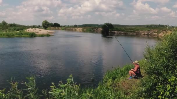 Il pescatore pesca sul fiume con una canna da pesca . — Video Stock