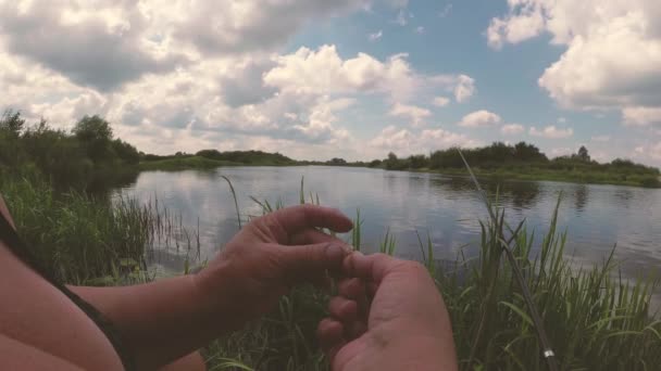 O pescador está pescando no rio com uma vara de pesca . — Vídeo de Stock