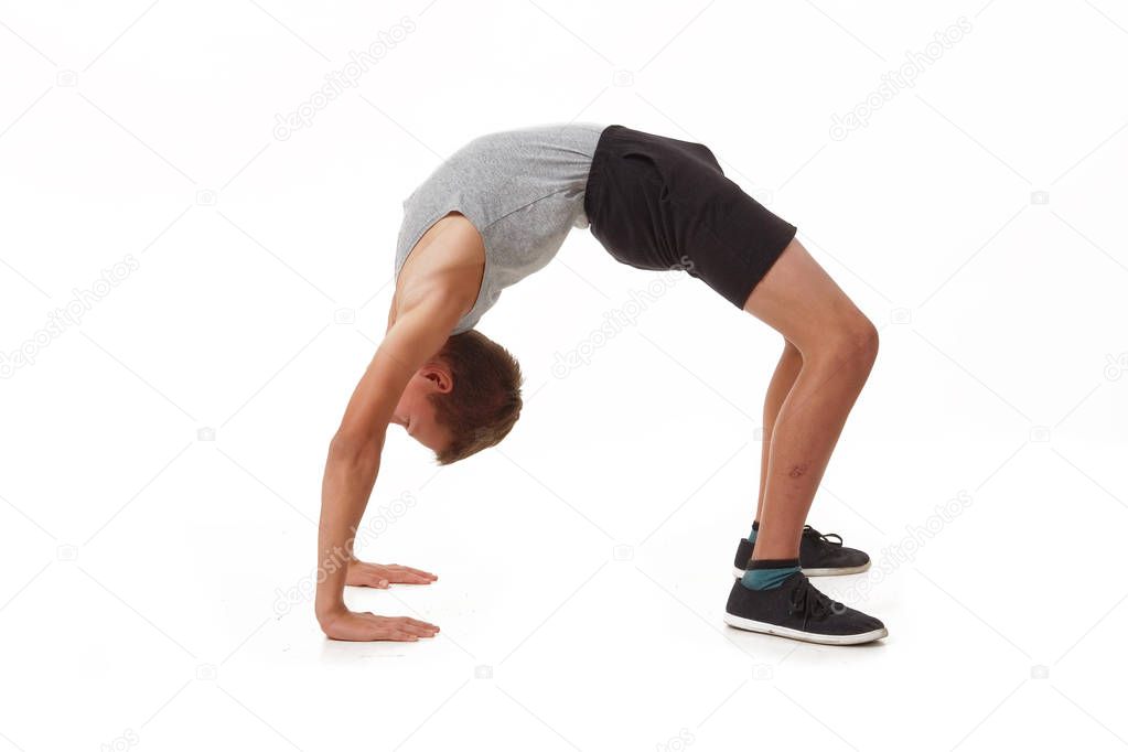 Teen in a T-shirt and shorts performs gymnastic exercises