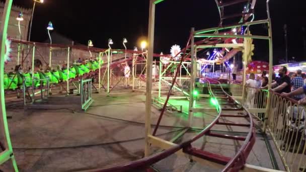Монтаньяна, Италия 15 августа 2018 года: праздник Феррагосто. Лунапарк поздним вечером. Дети катаются на карусели . — стоковое видео