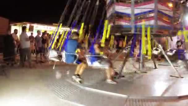 Montagnana, Italië, 15 augustus 2018: de vakantie van Ferragosto. Lunapark in de late avond. Kinderen rijden op de carrousel. — Stockvideo