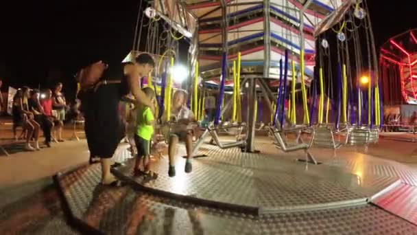 Montagnana, Włochy 15 sierpień 2018: wakacje Ferragosto. Lunapark w późnym wieczorem. Dzieci jeździć na karuzeli. — Wideo stockowe