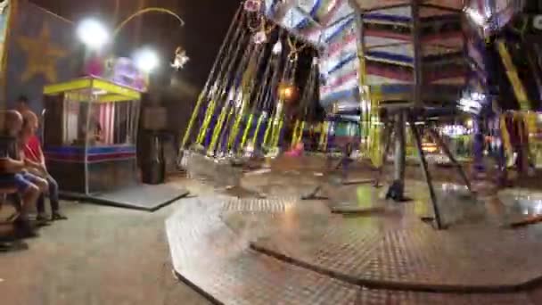 Montagnana, Italy August 15, 2018: the holiday of Ferragosto. Lunapark in the late evening. Children ride on the carousel. — Stock Video