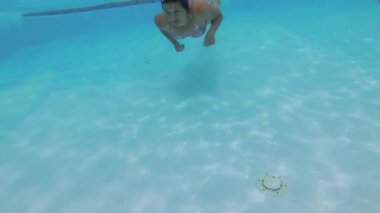 Genç su altında havuzunda yüzüyor.