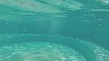 Genç su altında havuzunda yüzüyor.