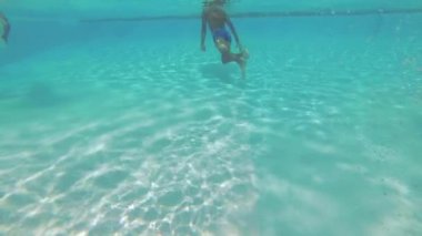 Genç su altında havuzunda yüzüyor.