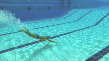 Genç su altında havuzunda yüzüyor.