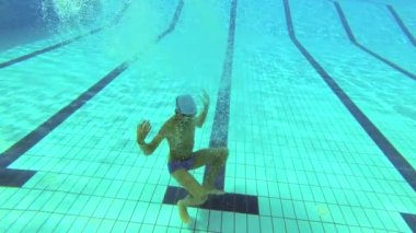 Genç su altında havuzunda yüzüyor.