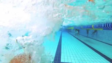 Genç su altında havuzunda yüzüyor.