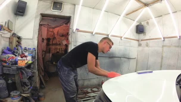 Молодий чоловік ремонтує автомобілі в гаражі . — стокове відео
