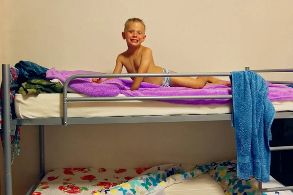 the boy is lying on a bunk bed