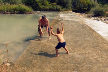 Baba ve oğul açık bir günde yaz aylarında nehir dağ banyo