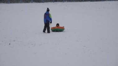 kış kar eğlenceli. Çocuk bir boru bir slayttan binmek..