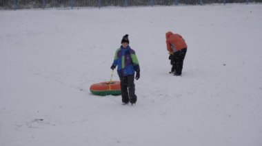 kış kar eğlenceli. Çocuk bir boru bir slayttan binmek..