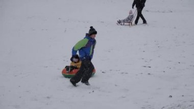 kış kar eğlenceli. Çocuk bir boru bir slayttan binmek..