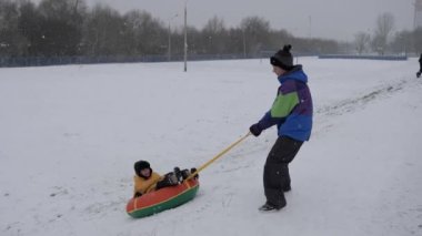 kış kar eğlenceli. Çocuk bir boru bir slayttan binmek..