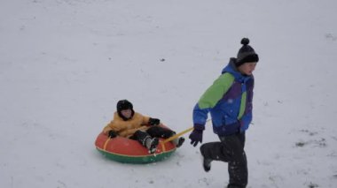 kış kar eğlenceli. Çocuk bir boru bir slayttan binmek..