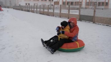 kış kar eğlenceli. Çocuk bir boru bir slayttan binmek..