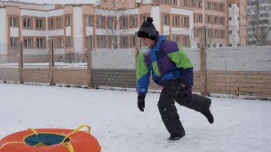 kış kar eğlenceli. Çocuk bir boru bir slayttan binmek..