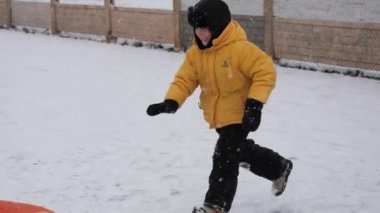 kış kar eğlenceli. Çocuk bir boru bir slayttan binmek..