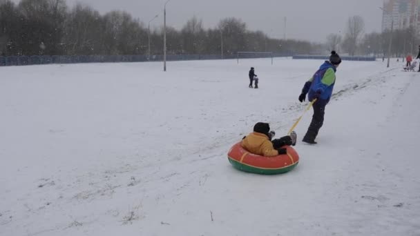 Sneeuw Winterpret Kinderen Rijden Een Buis Vanaf Een Dia — Stockvideo