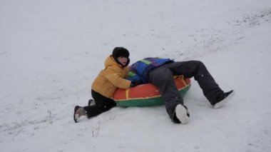 kış kar eğlenceli. Çocuk bir boru bir slayttan binmek..