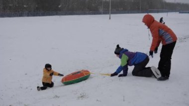 kış kar eğlenceli. Çocuk bir boru bir slayttan binmek..