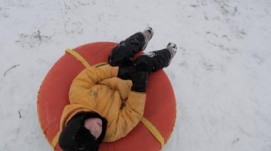 kış kar eğlenceli. Çocuk bir boru bir slayttan binmek..