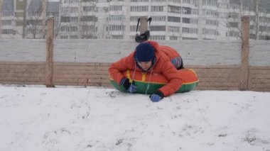 kış kar eğlenceli. Çocuk bir boru bir slayttan binmek..