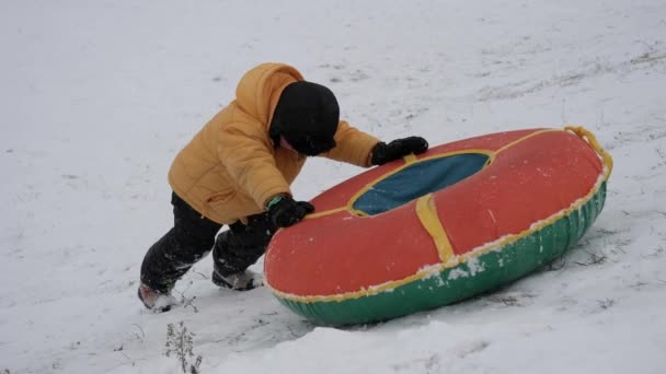 冬天雪的乐趣 孩子们从滑梯上乘坐管道 — 图库视频影像