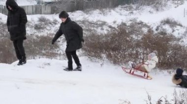 Gomel, Belarus - 1 Aralık 2018: Kış eğlenceli. Çocuklar ebeveynleri ile bir kar tepeye sledging git.