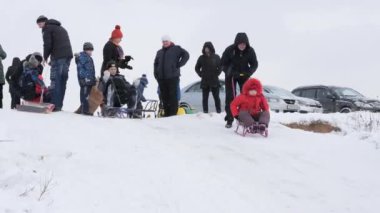Gomel, Belarus - 1 Aralık 2018: Kış eğlenceli. Çocuklar ebeveynleri ile bir kar tepeye sledging git.