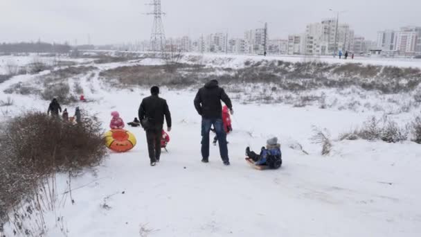 白俄罗斯戈梅利 2018年12月1日 冬季乐趣 有父母的孩子们在雪山上滑雪橇 — 图库视频影像