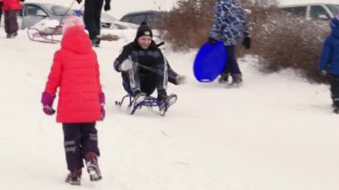 Gomel, Belarus - 1 Aralık 2018: Kış eğlenceli. Çocuklar ebeveynleri ile bir kar tepeye sledging git.