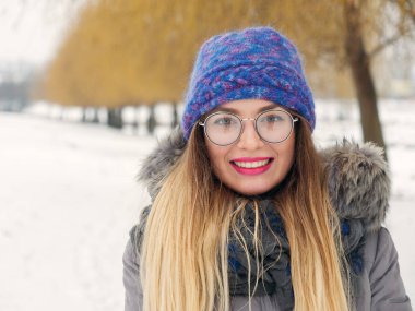 İçinde belgili tanımlık soğuk mavi bir şapka ve gözlük yuvarlak güzel mutlu kız