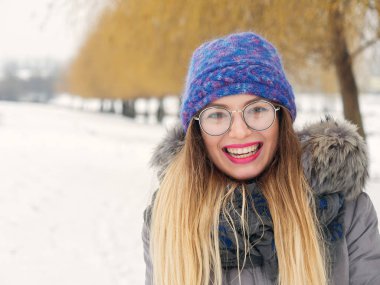 İçinde belgili tanımlık soğuk mavi bir şapka ve gözlük yuvarlak güzel mutlu kız
